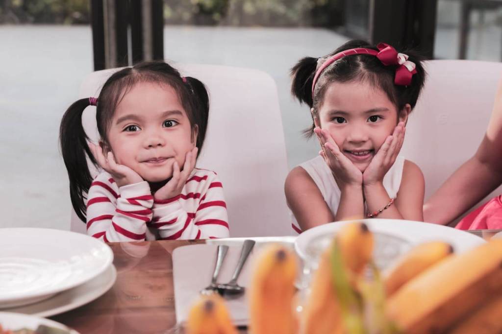 Two small girls sitting. It's important for children with autism to make friends.