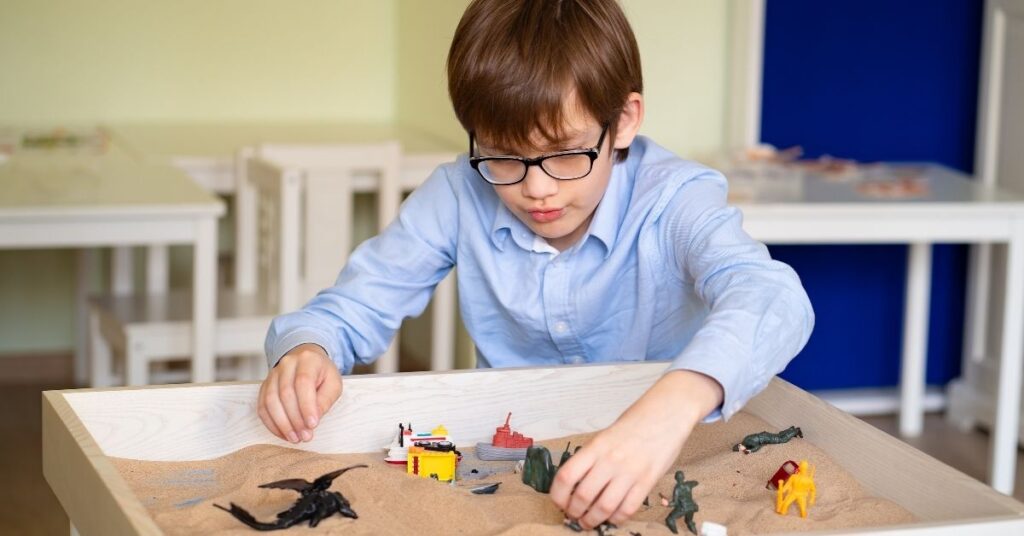 Boy playing in a sandbox. How to deal with autism stigma.