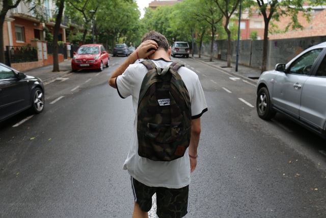 Teenage boy walking on street. When do you start a transition plan for your teenager with autism?