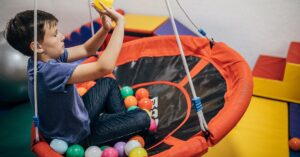 Boy on swing during occupational therapy session. Is sensory processing disorder related to autism?