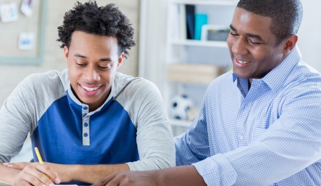 Dad talking to his teenage son at the table.