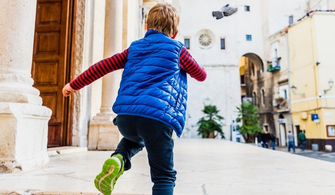 Boy running down a street.