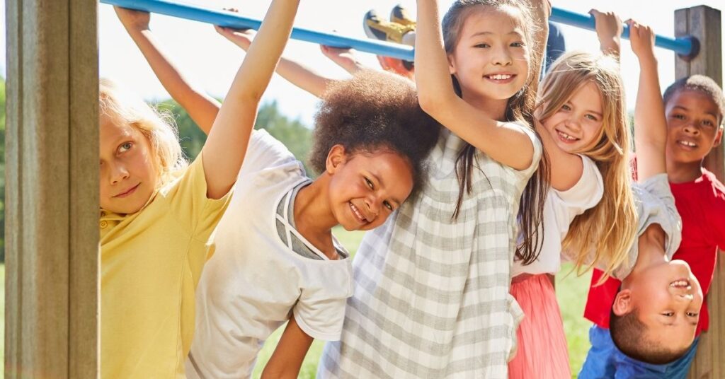 Children playing on playground equipment. How to help your autistic child make friends.