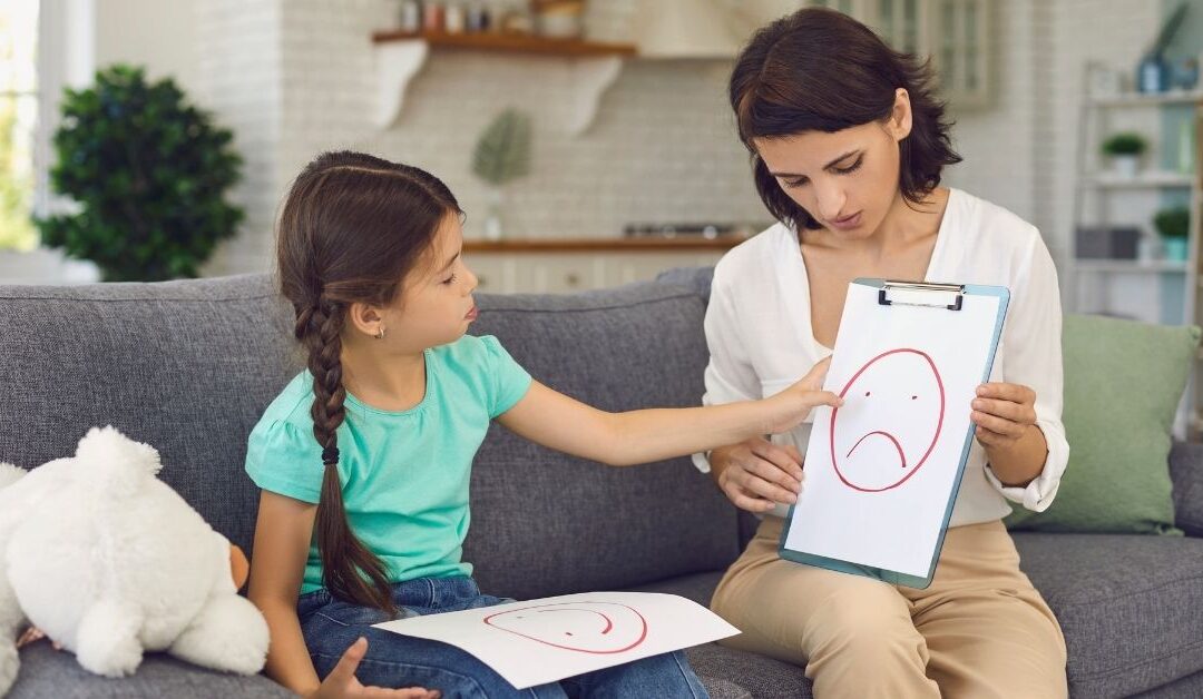 Girl looking at facial expression chart with adult