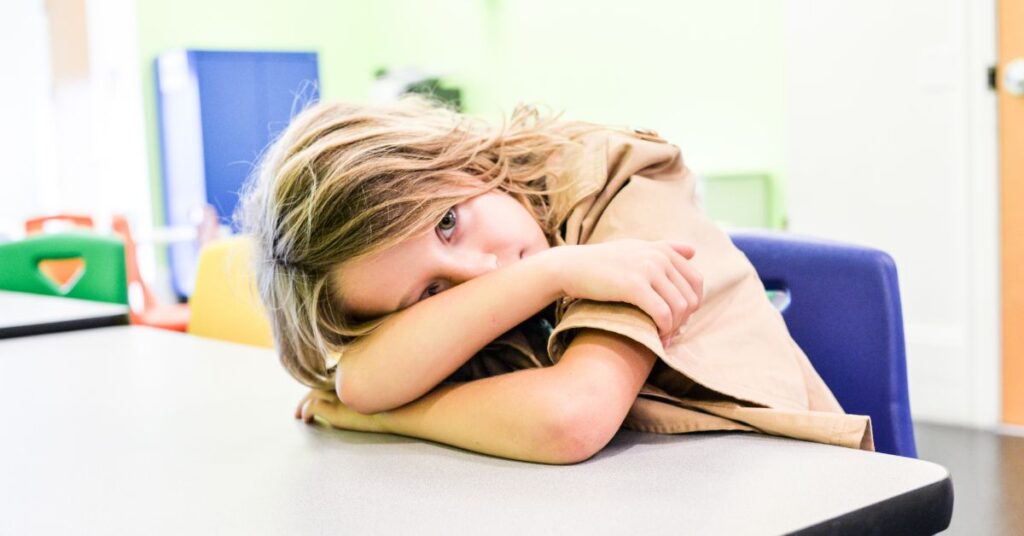 Girl with her head down on her desk in class