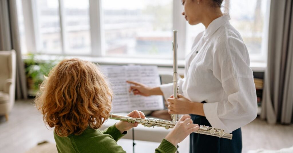 Girl learning to play the flute. Should you encourage your autistic child to learn to play a musical instrument?