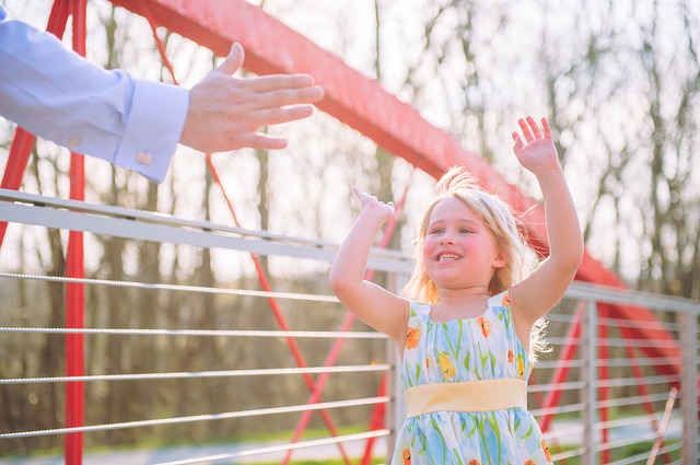 Girl giving adult a high five. Praising your child is important.