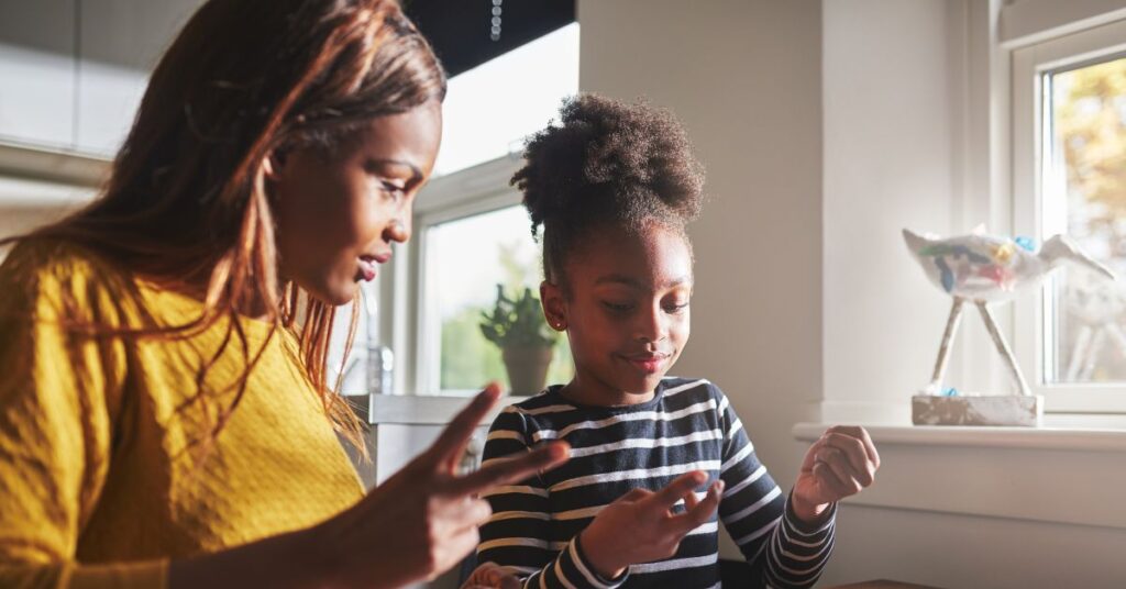 Mother sitting with daughter, helping her with homework. How to help your autistic ADHD child improve their working memory.