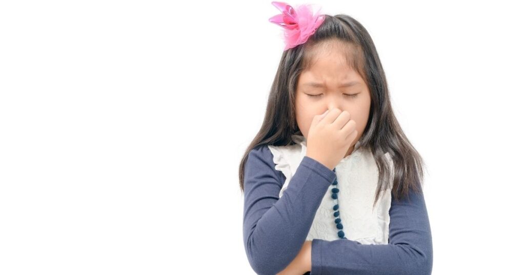 Girl pinching her nose. How can you prevent your autistic child from self-harm?