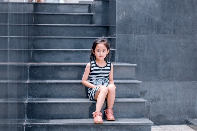 Girl sitting on steps. How does context blindness affect a child with autism?