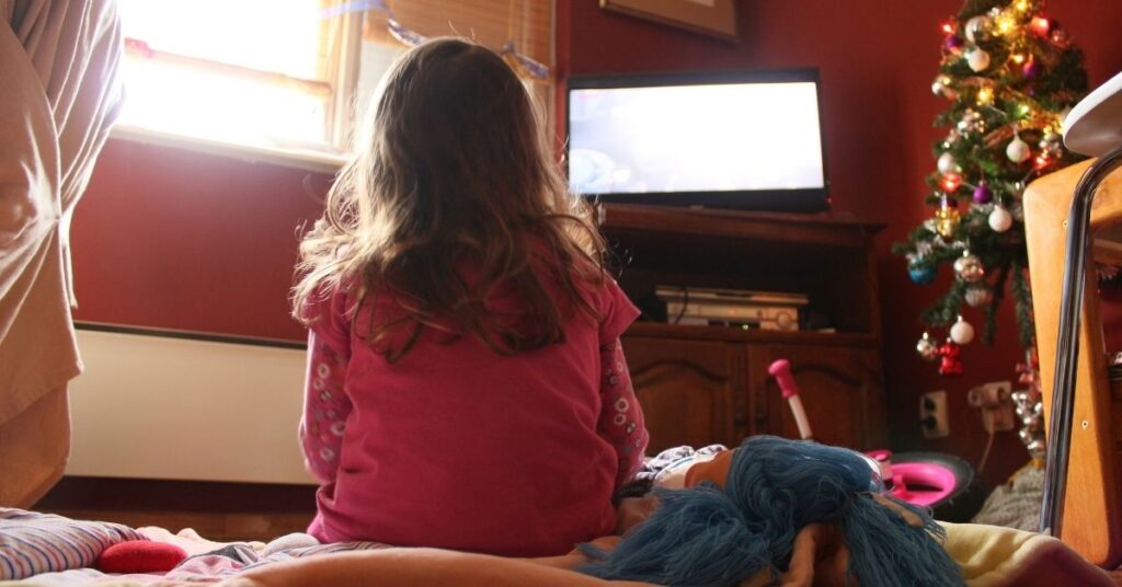 Girl watching TV. What are the pros and cons of screen time for children with autism and ADHD?