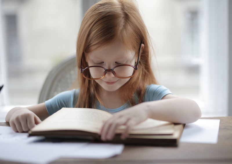 Girl reading. Prepare your child with autism/ADHD for new school year.