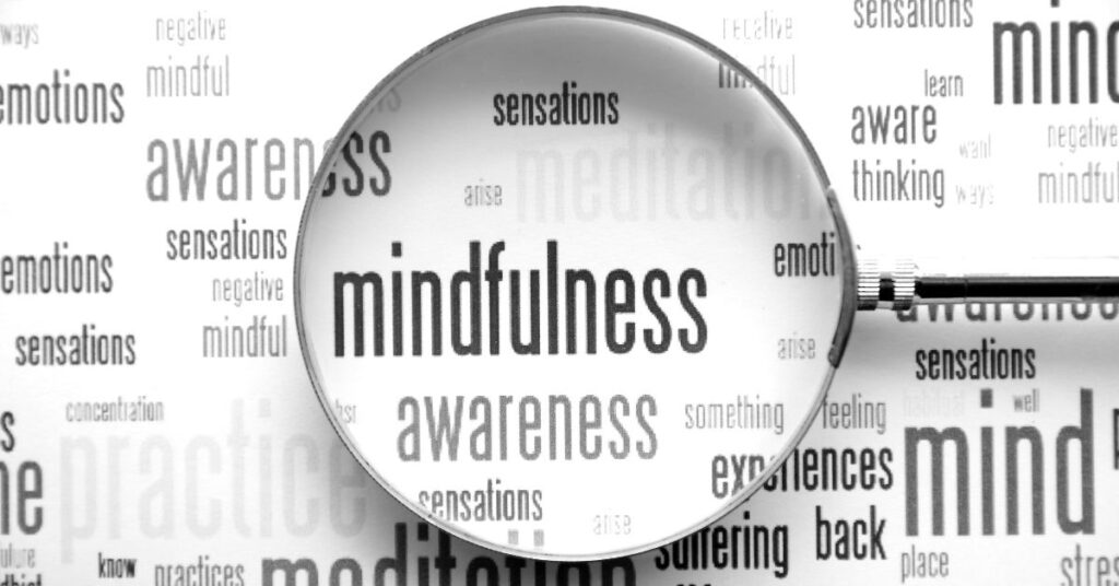 Mindfulness word cloud with a magnifying glass over the word mindfulness.