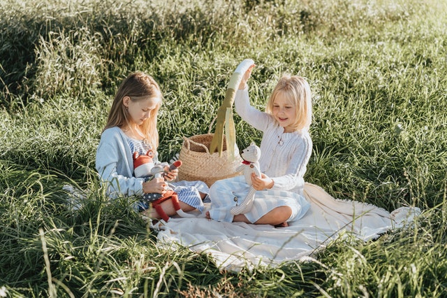 Little sisters on a picnic. Support siblings of children with autism.