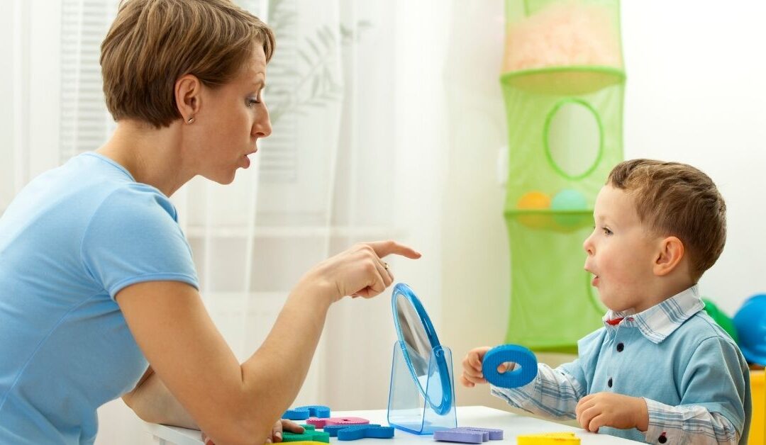 Speech therapist working with young boy.