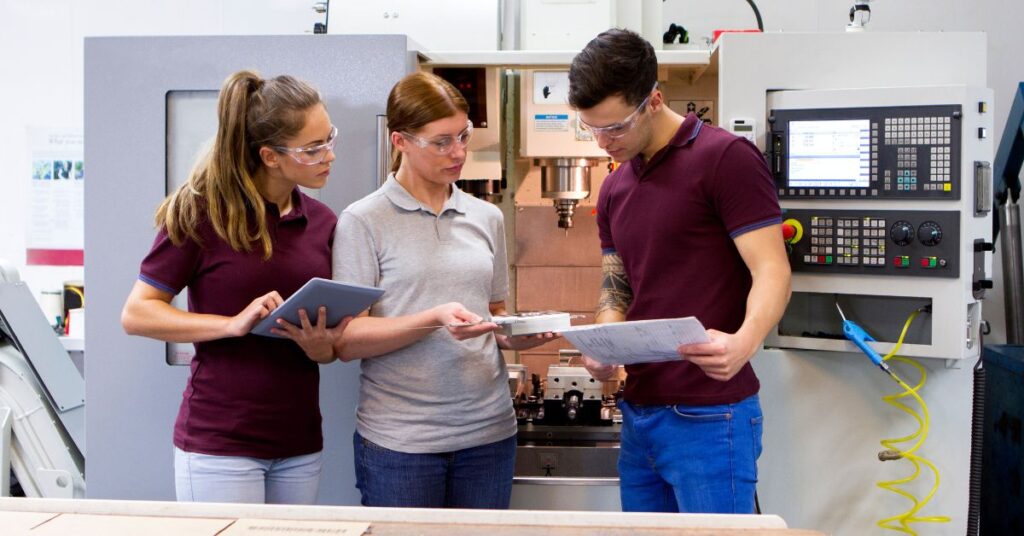 Three older teens or young adults in an electronics lab setting looking at a project. When should your teen disclose they have autism?