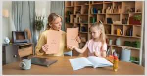 Therapist holding emotion cards for autistic girl. How can social-emotional learning help children with autism?